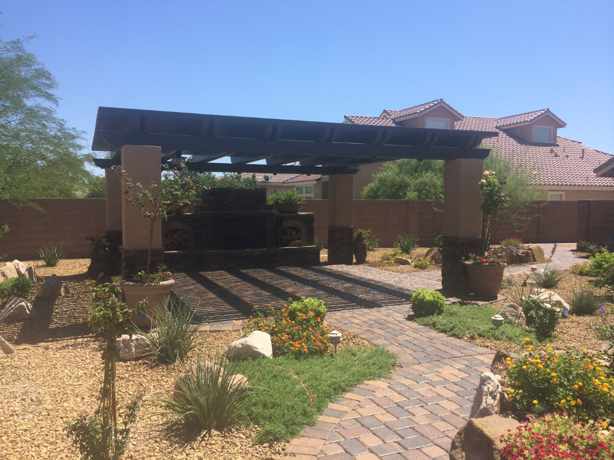 A sophisticated patio with a grill under a pergola, exemplifying luxury in outdoor living environments.