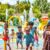 A vibrant backyard scene showcasing multiple splash pad ideas for summer fun. In the foreground, children of diverse backgrounds joyfully interact with playful water jets and colorful fountains, wearing modest casual clothing. The middle layer features a variety of splash pad designs, including a rainbow-colored water structure, whimsical animal figures spraying water, and interactive water games surrounded by mats. In the background, a sunny garden with greenery, blooming flowers, and a bright blue sky creates a cheerful atmosphere. The lighting is warm and inviting, mimicking a summer afternoon glow. The scene captures the essence of joy and laughter, encouraging outdoor play and water fun. Focused perspective with a slight tilt to emphasize depth and engagement.